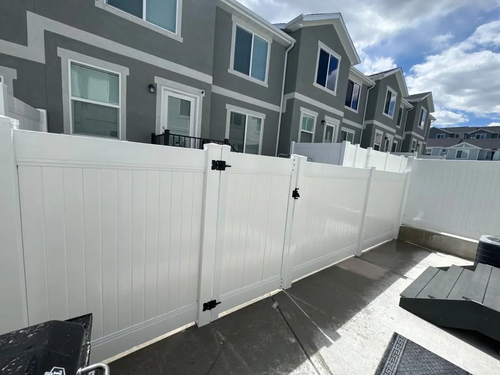 White vinyl fence and gates enclosing townhome patios